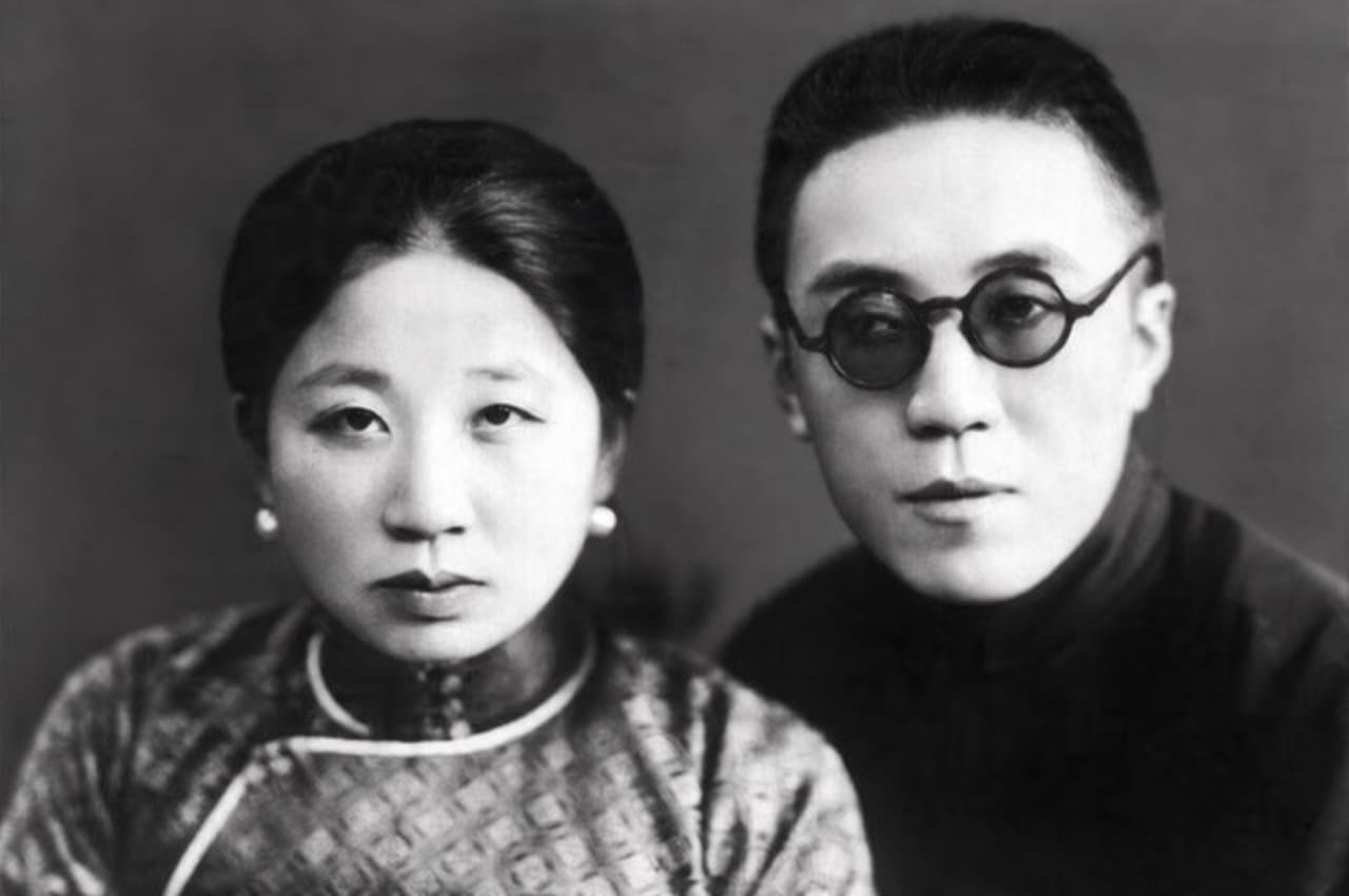 黑白近身人像照，素灰色背景。左側為過純華女士，髮髻盤起，戴珍珠耳環，著花紋立領旗袍；右側為涵靜老人（李玉階先生），頭髮短平，戴圓形厚框眼鏡，著深色高領上衣。二人並肩面向鏡頭，神情沉靜。